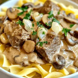 - 2 pounds beef stew meat, cut into 1-inch cubes - 1 medium onion, finely diced - 3 cloves garlic, minced - 8 ounces mushrooms, sliced (choose between cremini or button) - 2 cups beef broth - 1 tablespoon Worcestershire sauce The main part of this dish is the beef stew meat. It gives a rich flavor. Pair it with onion and garlic for a strong base. The mushrooms add a nice texture and earthy taste. Beef broth enhances the overall taste, while Worcestershire sauce adds a hint of umami. - 1 teaspoon dried thyme - 1 teaspoon sweet paprika - Salt and pepper to taste Spices elevate this dish. Dried thyme brings warmth and depth. Sweet paprika adds a colorful touch and a mild flavor. Adjust salt and pepper to your liking for a balanced taste. - 1 cup sour cream - 4 tablespoons all-purpose flour - 3 tablespoons olive oil - Fresh parsley leaves, chopped, for garnish - Cooked egg noodles, for serving Sour cream creates a creamy texture. It balances the richness of the beef. Flour thickens the sauce, making it stick to the noodles. Olive oil is vital for sautéing. Fresh parsley adds color and freshness. Serve it all over cooked egg noodles for a hearty meal. First, we need to brown the beef. Heat 2 tablespoons of olive oil in a large skillet over medium-high heat. Once hot, add the beef stew meat in batches. Do not overcrowd the pan. Brown the meat on all sides for about 4-5 minutes. This step locks in flavor. After browning, carefully transfer the beef to the slow cooker. Make sure to leave the tasty drippings in the skillet. Next, let’s sauté the vegetables. In the same skillet, add the remaining tablespoon of olive oil. Then, toss in the finely diced onion and minced garlic. Sauté for 2-3 minutes until they smell good and soften. Now, add the sliced mushrooms. Cook them for another 4-5 minutes. This helps the mushrooms soften and release their moisture. Now, it's time to mix everything together. Add the sautéed onion, garlic, and mushrooms to the slow cooker with the browned beef. Pour in 2 cups of beef broth. Then, add 1 tablespoon of Worcestershire sauce, 1 teaspoon of dried thyme, and 1 teaspoon of sweet paprika. Season with salt and pepper to your taste. Gently stir to combine all ingredients evenly. Let’s thicken our sauce for a creamy finish. About 30 minutes before serving, take a small bowl. Whisk together 1 cup of sour cream and 4 tablespoons of all-purpose flour until smooth. Gradually add this mixture to the slow cooker. Stir gently to avoid lumps. Increase the heat to high, cover it, and let it cook for another 30 minutes. This will help the sauce thicken nicely. After the sauce thickens, taste it. Adjust the seasoning if needed. To serve, place a bed of cooked egg noodles on each plate. Ladle the rich beef stroganoff over the noodles. For a pop of color, sprinkle freshly chopped parsley on top. You can also serve some crusty bread on the side to soak up the sauce. Enjoy your comforting meal! - Avoid overcrowding the skillet: When you add too much beef, it steams instead of browns. Work in batches to get that nice golden color. - Ensuring even cooking for flavor enhancement: Brown all sides of the beef. This builds great flavor and makes your dish more tasty. - Techniques to prevent lumps in the sauce: Mix sour cream and flour in a separate bowl first. This keeps your sauce smooth and creamy. - Timing for when to thicken the sauce: Add the sour cream mixture about 30 minutes before serving. This helps the sauce thicken just right. - Using fresh herbs: Fresh parsley adds a bright touch. You can also try thyme for an earthier flavor. - Adjusting seasoning for personal taste: Always taste before serving. Add more salt or pepper to make it just how you like it. {{image_4}} You can switch up the beef in your stroganoff. Try chicken or pork for lighter options. Both meats cook well in a slow cooker and soak up flavor. For a vegetarian twist, use mushrooms as the main protein. Portobello or cremini mushrooms add a rich taste. They give you that hearty feel without the meat. Want to add depth to your sauce? A splash of white wine works wonders. It enhances the flavor and adds a nice zing. If you need creamy alternatives for sour cream, consider Greek yogurt or cashew cream. These options keep the dish rich without losing the creaminess. While egg noodles are classic, you can try serving beef stroganoff with rice. It absorbs the sauce nicely. Mashed potatoes are also great; they create a cozy meal. For garnishes, fresh herbs like dill or chives add color and brightness. You can even sprinkle some crispy fried onions for crunch. To keep your Slow Cooker Beef Stroganoff fresh, place it in an airtight container. This keeps the flavors intact and prevents spills. You can store it in the fridge for up to three days. If you want to keep it longer, consider freezing it. To freeze, allow the stroganoff to cool completely. Transfer it into a freezer-safe container. Be sure to leave some space at the top for expansion. It will last in the freezer for about three months. When you're ready to eat, thaw it overnight in the fridge. For best results, reheat on the stove over low heat. Stir it often to avoid burning. You can also use a microwave. Heat in short bursts, stirring in between. Aim for about 2-3 minutes on medium power. Heat until it is hot throughout. Enjoy your comforting dish just like the first time! Yes, you can use frozen beef, but it is not ideal. Fresh beef browns better and adds more flavor. When you use frozen beef, it may release water when cooking. This can make your sauce thin. If you must use frozen beef, thaw it first. This step helps with browning and flavor. You can easily boost the flavor of your beef stroganoff. Here are some tips: - Use fresh herbs like thyme or parsley to enhance taste. - Add a splash of soy sauce for umami. - Stir in a dash of Dijon mustard for tanginess. - Experiment with different mushrooms for varied flavor. - Consider adding a bit of red wine for depth. This dish pairs well with several sides. Here are my top picks: - Cooked egg noodles are classic and absorb the sauce nicely. - Mashed potatoes offer a creamy base for the beef. - Rice can also work well, soaking up the rich flavors. - A side of crusty bread is perfect for dipping into the sauce. - Steamed green beans or a fresh salad provide nice contrast. Slow Cooker Beef Stroganoff combines simple ingredients for rich flavors. You need beef, onions, and mushrooms, plus spices for taste. Following careful steps ensures a delicious meal every time. Remember to adapt the recipe with substitutions or serving ideas for variety. Store leftovers properly to enjoy later. This dish is versatile, easy, and perfect for any occasion. Dive in and savor the comfort of your creation. Enjoy every bite!