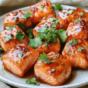 - 1 lb salmon fillet, skin removed and cut into bite-sized pieces - 3 tablespoons honey - 2 tablespoons Sriracha sauce - 1 tablespoon soy sauce - 1 teaspoon garlic powder - 1 teaspoon ginger powder - 1 tablespoon olive oil - Salt and pepper to taste - Chopped fresh cilantro, for garnish For this recipe, you will need one pound of salmon. This amount serves four people. Use three tablespoons of honey for sweetness. Two tablespoons of Sriracha bring heat. One tablespoon of soy sauce adds depth. One teaspoon each of garlic and ginger powder enhances flavor. One tablespoon of olive oil helps the marinade stick. Salt and pepper round out the taste. Lastly, cilantro gives a fresh finish. If you don’t have honey, maple syrup works well. For Sriracha, try another hot sauce like chili paste. Soy sauce can be swapped with tamari for gluten-free options. Garlic and ginger powders can be replaced with fresh minced versions, but adjust the amounts. You can skip the olive oil if you prefer a lighter marinade. Fresh herbs like parsley or green onions also make great garnishes. To start, you need to make the marinade. Grab a medium mixing bowl. Add 3 tablespoons of honey. Then, pour in 2 tablespoons of Sriracha sauce. Next, add 1 tablespoon of soy sauce. Sprinkle in 1 teaspoon of garlic powder and 1 teaspoon of ginger powder. Finally, pour in 1 tablespoon of olive oil. Add a pinch of salt and pepper too. Whisk all these ingredients together until they blend smoothly. This mixture will give your salmon a sweet and spicy kick. Now, it’s time to marinate the salmon. You should have one pound of salmon fillet, cut into bite-sized pieces. Gently add the salmon pieces into the marinade. Make sure each piece is covered well with the sauce. Cover the bowl with plastic wrap or a lid. Allow the salmon to marinate for at least 15 minutes. If you have more time, you can leave it in the fridge for up to 1 hour. This lets the flavors soak in deeply. Once the salmon has marinated, preheat your air fryer to 390°F (200°C). This step is important for crispy bites. After preheating, take the salmon out of the marinade and place it in the air fryer basket. Arrange the pieces in a single layer. Avoid overcrowding the basket; this helps them cook evenly. Air fry the salmon for about 8 to 10 minutes. Make sure to shake the basket halfway through. This ensures even crisping. When done, the salmon should be cooked through and crispy on the edges. Carefully transfer the salmon bites to a serving plate. Now, they’re ready to be enjoyed! I recommend cooking your salmon bites at 390°F (200°C). This high heat gives a nice crisp. Aim for about 8-10 minutes. Check it halfway and shake the basket for even cooking. If your salmon is thick, it may need a little extra time. To ensure perfectly cooked salmon, marinate for at least 15 minutes. This helps the flavors soak in. If you have time, let it sit for 1 hour in the fridge. This makes a big difference in taste. When you cook, look for a firm texture. The fish should flake easily with a fork. Garnish with chopped fresh cilantro for a pop of color. You can also use lime slices on the platter. This adds a nice contrast and freshness. For extra heat, drizzle more Sriracha on top. Pair it with a cooling cucumber salad to balance the spice. Present everything nicely on a large platter for a feast that looks great! {{image_4}} If you want to change up the taste, try different sauces. For a sweet touch, you can use teriyaki sauce instead of honey. This gives a nice blend of sweet and salty. For a tangy kick, mix in some lime juice with the Sriracha. You can also use a spicy BBQ sauce for a smoky flavor. Each sauce offers a new twist to the dish. Salmon is great, but feel free to try other seafood. Shrimp works wonderfully with the same marinade. Just adjust the cooking time to about 6-8 minutes. You can also use firm white fish like cod or halibut. Cut it into bite-sized pieces and follow the same steps. Each type of fish brings its unique flavor to the dish. Pair these salmon bites with various sides to enhance your meal. A cool cucumber salad balances the heat well. You can also serve them with jasmine rice for a filling option. Lime wedges add a fresh zest when served on the side. If you want extra heat, drizzle more Sriracha on top before serving. These pairings make the dish more delicious and enjoyable. To keep your salmon bites fresh, place them in an airtight container. You want to store them in the fridge. They stay good for about 2-3 days. If you need to stack them, use parchment paper between layers. This helps keep them from sticking together. When you’re ready to enjoy leftovers, reheating is easy. Use your air fryer for the best results. Set it to 350°F (175°C) and heat for about 5 minutes. This keeps the salmon crispy. You can also use a microwave, but it may make the salmon a bit soggy. If you use the microwave, heat in short bursts to avoid overcooking. Freezing is a great option if you want to save some bites. Place the cooled salmon in a single layer on a baking sheet. Freeze it for about an hour. Once firm, transfer the salmon to a freezer bag. Remove as much air as possible. This way, it stays good for up to 3 months. When you’re ready to eat, thaw it in the fridge overnight before reheating. You can check if the salmon is done by using a fork. Gently flake the salmon. If it flakes easily and has a light pink color, it is ready. The internal temperature should be 145°F (63°C). If you do not have a meat thermometer, look for a nice, crispy edge. This shows the salmon is cooked well. Yes, you can make this recipe using a regular oven. Preheat your oven to 400°F (200°C). Place the marinated salmon on a baking sheet lined with parchment paper. Bake for about 12-15 minutes or until the salmon flakes easily. This method will still give you tasty Honey Sriracha Salmon Bites. You can serve these salmon bites with a few tasty sides. A fresh cucumber salad will cool the heat from the Sriracha. You can also pair it with lime slices for a zesty kick. If you want more spice, drizzle extra Sriracha on top. Consider serving with rice or quinoa for a complete meal. This blog post covered key points for making delicious honey sriracha salmon bites. You learned about ingredients, measurements, and substitutions. We went through each step, from marinade prep to cooking. I shared tips for cooking temperature, presentation, and variations. Lastly, we discussed storage and FAQs to help you troubleshoot. These easy recipes can impress anyone. Enjoy cooking and experimenting with these flavors for great meals!
