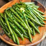 For this tasty dish, you will need: - 1 pound fresh green beans, trimmed - 3 tablespoons unsalted butter, melted - 4 cloves garlic, finely minced - 1 teaspoon lemon zest, freshly grated - 1 teaspoon garlic powder - 1 teaspoon onion powder - Salt and freshly cracked black pepper to taste - 2 tablespoons fresh parsley, finely chopped (for garnish) Fresh ingredients make a big difference in flavor. For this recipe, use fresh green beans. They bring a crisp texture and bright color. The garlic must be fresh, too. Fresh garlic offers a bold taste that dried garlic cannot match. The lemon zest adds a lovely brightness that ties everything together. When cooking, always choose the freshest ingredients you can find. If you need to make swaps, here are some ideas: - Green Beans: You can use snap peas or asparagus if green beans are not available. - Unsalted Butter: Olive oil can replace butter for a dairy-free option. - Garlic: Garlic powder can substitute for fresh garlic if you are in a pinch. Just use less of it, about half a teaspoon. - Parsley: You can use fresh basil or cilantro instead of parsley for a different flavor. These substitutions will change the taste slightly but will still make a delicious dish! Start by preheating your air fryer to 375°F (190°C). This step takes about 5 minutes. Preheating helps the green beans cook evenly and become crispy. In a large bowl, mix 3 tablespoons of melted butter with 4 minced garlic cloves. Add 1 teaspoon of lemon zest for a fresh touch. Then, include 1 teaspoon of garlic powder, 1 teaspoon of onion powder, and a pinch of salt and pepper. Whisk these ingredients until they blend well. This garlic butter sauce will give the beans rich flavor. Next, add 1 pound of trimmed green beans to the bowl. Toss them in the garlic butter sauce until each bean is coated. This step is key for flavor. After coating, place the green beans in the air fryer basket. Arrange them in a single layer. Avoid stacking the beans to let them crisp up nicely. Now it’s time to cook! Set your air fryer to cook for 8 to 10 minutes. Halfway through, shake the basket gently. This ensures the beans crisp up on all sides. When done, the green beans should be tender and crispy. Carefully transfer them to a serving platter. For a lovely finish, sprinkle chopped fresh parsley over the top. Enjoy your healthy, delicious green beans! To make your green beans crispy, start by preheating your air fryer. Set it to 375°F (190°C) for about 5 minutes. This helps cook the beans evenly. When you coat the beans in the garlic butter, make sure each bean is well covered. Spread them in a single layer in the air fryer basket. Overcrowding will make them steam instead of crisp. Shake the basket halfway through cooking to help them crisp on all sides. If you want to switch things up, you can use other veggies. Asparagus, broccoli, or Brussels sprouts work great too. Just adjust the cooking time based on thickness. Thinner veggies cook faster, while thicker ones may need a few extra minutes. To boost the flavor, consider adding more spices. A pinch of red pepper flakes gives a nice kick. You could also sprinkle some Parmesan cheese on top after cooking for a savory finish. Fresh herbs like thyme or rosemary can add a fragrant touch. Mix and match to find your favorite flavor! {{image_4}} You can add protein to your garlic butter green beans for a complete meal. Chicken, shrimp, or even tofu work well. Just cut the protein into bite-sized pieces. Toss them into the garlic butter sauce along with the green beans. Cook everything together in the air fryer. This adds flavor and makes your dish filling. Want to mix it up? Add nuts or cheese for crunch and creaminess. Almonds or walnuts add great texture. Sprinkle them over the green beans before air frying. You can also add cheese like parmesan or feta. Just toss it in after cooking for a melty finish. These additions can really elevate the dish. Feel free to swap out green beans for other veggies. Asparagus, zucchini, or broccoli are tasty choices. Just adjust the cooking time since some veggies cook faster. For example, zucchini may need less time than green beans. Mix and match to enjoy seasonal produce. This keeps your meals fresh and exciting. To keep your Air Fryer Garlic Butter Green Beans fresh, store them in an airtight container. Let them cool completely before sealing. This helps prevent moisture build-up, which can make them soggy. You can keep them in the fridge for up to three days. If you want to enjoy them later, consider the next steps. Reheating these green beans is easy. You can use your air fryer for the best results. Preheat the air fryer to 350°F (175°C). Place the green beans in the basket and cook for about 4 to 5 minutes. This will make them hot and crispy again. You can also use a microwave, but they may not stay as crispy. Yes, you can freeze green beans! However, it’s best to freeze them before cooking. Blanch the fresh beans in boiling water for 2-3 minutes. Then, cool them in ice water, drain, and pack them in freezer bags. This way, they can last for up to six months. When ready to cook, you can air fry them straight from the freezer. Just adjust the cooking time as needed. Yes, you can use frozen green beans. Just remember to adjust the cooking time. Frozen beans may need an extra minute or two. Always check for doneness. They should be tender and crisp. These green beans pair well with many dishes. You can serve them with grilled chicken, baked fish, or steak. They also go great with rice or quinoa. Add them to a salad for some crunch. To make more servings, simply double or triple the ingredients. Use more green beans, butter, and spices. Ensure your air fryer can handle the extra volume. Cook in batches if needed for even crispiness. You can prepare the garlic butter sauce ahead of time. Store it in the fridge for up to 2 days. Toss it with fresh beans just before air frying. This keeps your dish fresh and flavorful. Green beans are low in calories and high in vitamins. They are a great source of fiber, which aids digestion. They also contain antioxidants. These nutrients support overall health and wellness, making them a smart choice! You learned about making delicious Air Fryer Garlic Butter Green Beans. We covered key ingredients, from fresh to pantry staples, and shared easy swaps. I detailed step-by-step instructions to ensure perfect cooking each time. To enhance your dish, I offered tips for crispiness and talked about fun variations. Plus, you can store leftovers properly for later enjoyment. Remember, green beans are not just tasty; they’re healthy too! Try this recipe, and enjoy a quick, flavorful side dish that impresses.