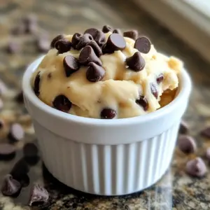 The key to making this single-serve chocolate chip edible cookie dough is simple. Here&rsquo;s what you need: - 1 tablespoon unsalted butter, softened - 1 tablespoon brown sugar - 1 tablespoon granulated sugar - 1/4 teaspoon vanilla extract - 1 tablespoon milk (or a dairy-free alternative) - 4 tablespoons all-purpose flour - 2 tablespoons chocolate chips - Pinch of salt Each ingredient plays a role. The unsalted butter gives the dough a rich flavor. Brown sugar adds a hint of caramel. Granulated sugar adds sweetness. Vanilla extract gives warmth and depth. Milk helps blend everything smoothly. All-purpose flour forms the dough base. Chocolate chips add that gooey goodness. A pinch of salt brings out all the flavors. Using high-quality ingredients can make a big difference in taste. If you want a dairy-free version, you can swap milk and butter for alternatives. Almond or oat milk works well. For butter, try coconut oil. Enjoy making this delightful treat! {{ingredient_image_1}} 1. Mixing the butter and sugars Start by taking a small mixing bowl. Add 1 tablespoon of softened unsalted butter, 1 tablespoon of brown sugar, and 1 tablespoon of granulated sugar. Use a fork to cream them together. Mix until it looks smooth. 2. Adding vanilla and milk Next, pour in 1/4 teaspoon of vanilla extract and 1 tablespoon of milk. You can use a dairy-free milk if you prefer. Stir the mixture well. Make sure everything is fully blended. 3. Incorporating flour Now, slowly add 4 tablespoons of all-purpose flour. Stir the dough gently. Keep mixing until it starts to come together nicely. 4. Folding in chocolate chips Finally, fold in 2 tablespoons of chocolate chips and a pinch of salt. Make sure they are evenly spread throughout the dough. This step adds a delightful sweetness. - Microwaving for a smoother consistency If you want a smoother cookie dough, pop your bowl in the microwave. Heat it for just 5 to 10 seconds. This warms it slightly and gives a lovely texture. Enjoy your treat straight from the bowl! To change the sweetness, you can adjust the sugar levels. If you like it sweeter, add more brown sugar or granulated sugar. For less sweetness, cut back on both sugars. You can even try adding a pinch of cocoa powder for a rich taste. Experiment until you find your perfect balance. If you prefer dairy-free, you have great options. Use coconut oil instead of butter. Almond milk or oat milk works instead of regular milk. This keeps the dough creamy and tasty without dairy. You won&rsquo;t miss the milk or butter at all. Serving your cookie dough can be fun and creative. Use a cute ramekin or a small bowl for a nice touch. Top it with extra chocolate chips for a pop of color. You can eat it straight from the bowl or share it with a friend. This cookie dough is perfect for a sweet snack anytime! Pro Tips Use Room Temperature Ingredients: Make sure your butter is softened to room temperature for easier mixing and a smoother dough. Try Different Mix-Ins: Feel free to customize your edible cookie dough by adding nuts, dried fruits, or different types of chocolate chips! Heat Treat the Flour: For safety, you can heat treat your flour in the microwave for 1 minute to eliminate any potential bacteria before using it. Chill Before Serving: For a firmer texture, refrigerate the cookie dough for about 10-15 minutes before enjoying! {{image_2}} You can get creative with your cookie dough! Try adding different flavors and textures to make it unique. Here are some fun ideas: - Chopped nuts: Walnuts or pecans add a nice crunch. - Cocoa powder: For a chocolatey twist, mix in a little cocoa powder. - Peanut butter: Add a spoonful for rich, nutty flavor. - Sprinkles: They add color and fun to your dough. Do you want to try other types of cookie dough? Here are some great ideas: - Vegan cookie dough: Use coconut oil instead of butter and almond milk. - Gluten-free dough: Swap all-purpose flour with almond flour or gluten-free flour. These options let everyone enjoy cookie dough! Make your cookie dough special for holidays or events. Here are a few ideas: - Holiday spices: Add cinnamon or nutmeg for a festive flavor. - Pumpkin spice: Mix in pumpkin puree and pumpkin spice for fall. - Red and green sprinkles: Use these for a fun Christmas treat. These twists make your cookie dough perfect for any occasion! To keep your cookie dough fresh, store it in a clean, airtight container. This helps to lock in moisture and flavor. If you use a bowl, cover it tightly with plastic wrap. This way, it won't dry out or pick up other odors from the fridge. When stored properly in the fridge, your edible cookie dough lasts about three days. Keep it at a temperature below 40&deg;F (4&deg;C). If you want to enjoy it later, just take it out and let it sit for a few minutes to soften before digging in! Yes, you can freeze this cookie dough for later use! Scoop it into small balls and place them on a baking sheet lined with parchment paper. Freeze them for about an hour, then transfer the balls to a freezer bag. They can last up to three months. When you're ready to enjoy, let them thaw in the fridge or warm them up slightly in the microwave. Is the cookie dough safe to eat raw? Yes, this cookie dough is safe to eat raw. I use heat-treated flour to kill any germs. You can also use oat flour or almond flour for a safe option. These flours work great and taste good too! Yes, you can make a larger batch. Just multiply each ingredient by the number of servings you want. For example, if you need four servings, use four times the ingredients. Mix them in a bigger bowl for easy handling. Enjoy sharing with friends! If the dough is too dry, add more milk. Start with one teaspoon at a time. Mix well and check the texture after each addition. You want it to be soft and sticky but not runny. - How to adjust ingredient ratios for desired texture? To adjust texture, play with the flour and milk amounts. More flour makes the dough thicker. More milk gives it a softer feel. Always add small amounts to avoid overdoing it. This way, you can find the perfect mix for your taste! You can create delicious cookie dough using simple ingredients like butter, sugars, and chocolate chips. The steps are easy: mix, combine, and fold. Remember to adjust sweetness or try dairy-free options for your needs. Get creative with flavors or festive themes. Store it right to keep it fresh, and feel free to freeze for later. Enjoy your cookie dough adventure and share it with friends. The joy of baking starts with you!