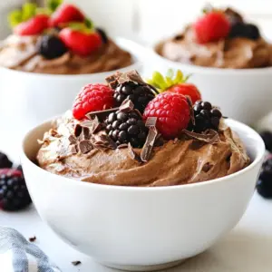To make Fluffy Chocolate Protein Fluff, you need these simple ingredients: - 1 cup Greek yogurt - 2 scoops chocolate protein powder - 1 tablespoon unsweetened cocoa powder - 2 tablespoons honey or maple syrup (adjust to taste) - 1 teaspoon vanilla extract - 1/4 teaspoon sea salt - 1/4 cup almond milk (or milk of your choice) - Optional toppings: dark chocolate shavings, fresh berries, or crushed nuts These ingredients come together to create a delicious and healthy treat. Greek yogurt gives a creamy base, while the chocolate protein powder adds a rich flavor. The unsweetened cocoa powder enhances the chocolate taste without extra sugar. You can adjust the sweetness with honey or maple syrup. Vanilla extract brings warmth to the mix, and a pinch of sea salt balances the flavors. Almond milk makes it light and fluffy, giving the perfect mousse-like texture. Don't forget the toppings! They add fun and extra flavor. {{ingredient_image_1}} - First, grab a mixing bowl. Add 1 cup of Greek yogurt. - Next, scoop in 2 scoops of chocolate protein powder. - Add 1 tablespoon of unsweetened cocoa powder for a rich taste. - Pour in 2 tablespoons of honey or maple syrup for sweetness. - Then, add 1 teaspoon of vanilla extract for flavor. - Finally, sprinkle in 1/4 teaspoon of sea salt to enhance taste. Now, it&rsquo;s time to mix! Using a handheld mixer or a whisk, beat the mixture on medium speed. You want to do this for about 1-2 minutes. Make sure it is creamy and smooth with no lumps. Next, we achieve fluffiness. Gradually add 1/4 cup of almond milk while mixing. Continue until the mixture is light and fluffy. This milk helps create that mousse-like texture you will love. Once your protein fluff is airy, taste it. If you want it sweeter, just add a bit more honey or maple syrup. Now, transfer your fluffy mixture into serving bowls or glasses. This gives each person their own portion to enjoy. For an extra fun touch, garnish each serving. You can sprinkle dark chocolate shavings on top. Fresh berries or crushed nuts also add great texture and flavor. Enjoy your delicious treat! If you need dairy-free options, swap Greek yogurt for coconut yogurt. It has a similar texture and flavor. For sweetness, use agave syrup instead of honey or maple syrup. Adjust the amount to fit your taste. Toppings can make your protein fluff even better. Try dark chocolate shavings, fresh berries, or crushed nuts. They add great texture and taste. To make your fluff extra light, use a handheld mixer. Mix for one to two minutes on medium speed. This will help create a creamy texture without lumps. When you add almond milk, do it slowly while mixing. This step is key to getting that airy mousse-like consistency. Pro Tips Use Full-Fat Greek Yogurt: For an even creamier texture, opt for full-fat Greek yogurt instead of low-fat versions. Chill Before Serving: Allow the protein fluff to chill in the refrigerator for 30 minutes before serving for an enhanced, refreshing taste. Experiment with Flavors: Feel free to add a pinch of cinnamon or a spoonful of peanut butter to customize the flavor profile to your liking. Perfect the Consistency: Adjust the amount of almond milk based on your desired fluffiness. Less milk will make it denser, while more will lighten it further. {{image_2}} You can change the taste of your Fluffy Chocolate Protein Fluff easily. Start by trying different protein powder flavors. Vanilla or strawberry can give you a new twist. You might also add fruits or spices to make it unique. A pinch of cinnamon can warm up the flavor. Cherries or bananas can add a fruity touch. Just mix them in after you've made the fluff. This way, you keep it fun and fresh. You can serve your fluff in many delicious ways. One great idea is to make parfaits. Layer the fluff with granola and fresh fruit in a glass. This adds crunch and color. Plus, it looks pretty! You can also use the fluff in smoothies. Blend it with your favorite fruits for a creamy drink. This adds protein and keeps it tasty. With these ideas, you can enjoy your Fluffy Chocolate Protein Fluff in new ways! To keep your Fluffy Chocolate Protein Fluff fresh, use an airtight container. Glass or plastic containers work well. Make sure to seal it tightly. This will help keep out moisture and air. When you store it, place it in the fridge right away. Try to eat it within a few days for the best taste. In the fridge, your fluff lasts about 3 to 5 days. It may lose some fluffiness over time, but the flavor stays good. If you notice any change in smell or texture, it&rsquo;s best to toss it out. Always trust your senses when it comes to food safety. Fluffy Chocolate Protein Fluff is a healthy treat because it uses Greek yogurt. Greek yogurt is high in protein and probiotics. Protein helps build muscle and keeps you full. The cocoa powder adds flavor without lots of sugar. Honey or maple syrup gives just enough sweetness. This mix keeps your energy up while tasting great. Yes, you can use whey protein powder instead of plant-based protein. Whey protein blends well and adds creaminess. It also has a higher protein content. Just be sure to adjust the milk to achieve the right texture. Both types of protein will create a delicious fluff. To make this recipe vegan-friendly, swap Greek yogurt for a plant-based yogurt. Look for one with high protein. Use a plant-based protein powder too. Replace honey with maple syrup or agave nectar for sweetness. With these swaps, you still get a tasty and fluffy dessert. Great toppings for your protein fluff include dark chocolate shavings and fresh berries. Crushed nuts add a nice crunch. You can also try coconut flakes or granola for extra texture. These toppings enhance the flavor and make your fluff look pretty. Yes, you can freeze the protein fluff. Place it in an airtight container. It will last up to two months in the freezer. When you're ready to eat it, let it thaw in the fridge. Stir it well before serving to get that fluffy texture back. This blog post covered the basics of making Fluffy Chocolate Protein Fluff. We explored key ingredients like Greek yogurt and protein powder. I shared step-by-step instructions and serving tips to help you create the perfect treat. Ingredient substitutions and flavor variations can enhance your recipe. For storage, I provided advice on keeping your fluff fresh. In conclusion, this fluffy treat is easy, fun, and healthy. Experiment and enjoy your creation!