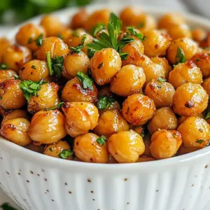You need the following main ingredients for this tasty snack: - 1 can (15 oz) chickpeas, drained and rinsed - 2 tablespoons olive oil Chickpeas are the star of this dish. They provide protein and fiber. Rinsing helps remove extra sodium and makes them crispier later. For a great flavor, gather these seasoning components: - 1 tablespoon ranch seasoning mix - 1 teaspoon garlic powder - 1/2 teaspoon onion powder - 1/2 teaspoon smoked paprika - Salt and pepper to taste These spices bring life to the chickpeas. The ranch mix adds a zesty kick, while garlic and onion powder give depth. Smoked paprika adds a warm, smoky taste. To make your dish pop, consider these optional garnishes: - Fresh parsley, chopped Garnishing with fresh parsley adds color and freshness to your snack. It makes the dish look nice and gives a bit of herb flavor. {{ingredient_image_1}} 1. Preheat the oven. Start by setting your oven to 400&deg;F (200&deg;C). This heat helps crisp the chickpeas. 2. Prepare the baking sheet. Line a baking sheet with parchment paper. This makes for easy cleanup. 3. Dry the chickpeas. Open the can of chickpeas, drain, and rinse them under cold water. Pat them dry with paper towels. Removing moisture is key for crispiness. 4. Mix the ingredients. In a large bowl, add the dried chickpeas, olive oil, ranch seasoning, garlic powder, onion powder, smoked paprika, salt, and pepper. Toss everything well. You want each chickpea coated in flavor! 5. Spread the chickpeas. Place the seasoned chickpeas in a single layer on the baking sheet. This helps them roast evenly. 6. Roast them. Put the baking sheet in the oven. Roast for 25-30 minutes. Be sure to shake the pan halfway through. This ensures they cook evenly. 7. Check for doneness. Look for golden brown color and a crispy texture. When they are done, take them out of the oven. 8. Cool them down. Let the roasted chickpeas cool for a few minutes. They will crisp up even more as they cool. - Dry them well. Moisture is the enemy of crispiness. Make sure to dry them thoroughly. - Use enough oil. Olive oil helps achieve that crunchy texture. Don&rsquo;t skimp on it! - Don&rsquo;t overcrowd. Give each chickpea space on the baking sheet. This helps them roast rather than steam. - Shake it up! Shaking the pan halfway through ensures even cooking. It&rsquo;s a simple step that makes a big difference. Enjoy your crunchy, flavorful ranch roasted chickpeas as a healthy snack or appetizer! To roast chickpeas well, start by drying them. Use paper towels to soak up extra moisture. This step is key for getting them crispy. Spread the chickpeas in a single layer on the baking sheet. Avoid crowding them, or they will steam instead of roast. Set your oven to 400&deg;F (200&deg;C). This high heat helps to crisp the chickpeas. Roast them for 25-30 minutes. Shake the pan halfway through to ensure even cooking. Let them cool after roasting; they will crisp up more as they cool. To boost the flavor, try adding fresh herbs like parsley or dill. You can also mix in a bit of lemon zest for brightness. If you like heat, add some cayenne pepper or chili powder. These spices pair well with the ranch seasoning. Experiment with different seasoning blends. You might enjoy taco seasoning or garlic and herb mixes. Adjust the salt and pepper to fit your taste. A common mistake is not drying the chickpeas enough. Wet chickpeas will not get crispy. Another mistake is not shaking the pan during roasting. This can cause uneven cooking and browning. Be careful with the cooking time. Over-roasting can lead to hard chickpeas. Always check for a nice golden color. If you notice some are browning faster, remove them early. Pro Tips Dry Chickpeas Thoroughly: Make sure to pat the chickpeas dry with paper towels after rinsing. The drier they are, the crispier they will become when roasted. Experiment with Seasonings: Feel free to customize the seasoning mix by adding your favorite spices or herbs to create a unique flavor profile. Use a High-Quality Olive Oil: Opt for a good quality olive oil for the best flavor. It will enhance the overall taste of the roasted chickpeas. Store in an Airtight Container: To maintain their crispiness, store leftover roasted chickpeas in an airtight container at room temperature. {{image_2}} You can change up the flavor of your ranch roasted chickpeas with different seasonings. Try using taco seasoning for a spicy kick. You can also use Italian herbs for a fresh twist. For a smoky taste, add chipotle seasoning. Each blend gives a unique flavor that keeps things fun! Mixing in veggies is a great way to boost nutrition. Cut up bell peppers, zucchini, or carrots. Toss them with the chickpeas and seasonings before roasting. They will cook nicely together and add color to your dish. You can even add some corn for a sweet crunch! Ranch roasted chickpeas make a perfect snack for busy days. You can pack them in small containers for easy grab-and-go. Pair them with sliced veggies or whole-grain crackers. They also work well on top of salads for added crunch. Enjoy this tasty snack whenever you need a quick bite! To store leftover roasted chickpeas, let them cool completely. Place them in an airtight container. If you leave them out, they may become soft. You can use a glass jar or a plastic container. Make sure to seal it tightly to keep them fresh. Reheat the chickpeas in the oven to keep them crispy. Preheat the oven to 350&deg;F (175&deg;C). Spread the chickpeas on a baking sheet in a single layer. Heat them for about 10 minutes. You can also use an air fryer. Set it to 350&deg;F (175&deg;C) and cook for about 5 minutes. Roasted chickpeas can last up to one week when stored properly. Keep them in a cool, dry place. Avoid storing them in the fridge, as moisture can make them soggy. For the best taste, eat them within a few days. If they lose their crunch, you can always reheat them. Yes, you can use an air fryer to make ranch roasted chickpeas. The air fryer cooks them faster and makes them super crispy. Just preheat the air fryer to 400&deg;F (200&deg;C). Toss the chickpeas with olive oil and seasoning. Place them in the basket in a single layer. Cook for about 15 to 20 minutes, shaking the basket halfway through. Keep an eye on them to avoid burning. Ranch roasted chickpeas make a great snack on their own. You can serve them in a small bowl as an appetizer. They pair well with fresh veggies, like carrots and celery. You can also enjoy them with dips, such as hummus or ranch dressing. For a fun twist, sprinkle them on salads for extra crunch. Yes, ranch roasted chickpeas are a healthy snack. They are high in protein and fiber, which keeps you full. Chickpeas contain vitamins and minerals, like iron and magnesium. Using olive oil adds healthy fats. Just be mindful of the amount of seasoning you use, as some ranch mixes can be high in sodium. Making homemade ranch seasoning is easy! You will need: - 1 tablespoon dried dill - 1 tablespoon garlic powder - 1 tablespoon onion powder - 1 tablespoon dried parsley - 1 teaspoon salt - 1 teaspoon black pepper Mix all the ingredients in a bowl. Store it in an airtight container. You can add this mix to your chickpeas for a fresh ranch flavor. Ranch roasted chickpeas are easy to make and taste great. We covered key ingredients, preparation steps, and tips for crispy results. You can explore variations and learn how to store leftovers properly. Remember to avoid common mistakes for the best outcome. With these pointers, you can enjoy a crunchy, flavorful snack that's also healthy. Dive into this recipe and make it your own!